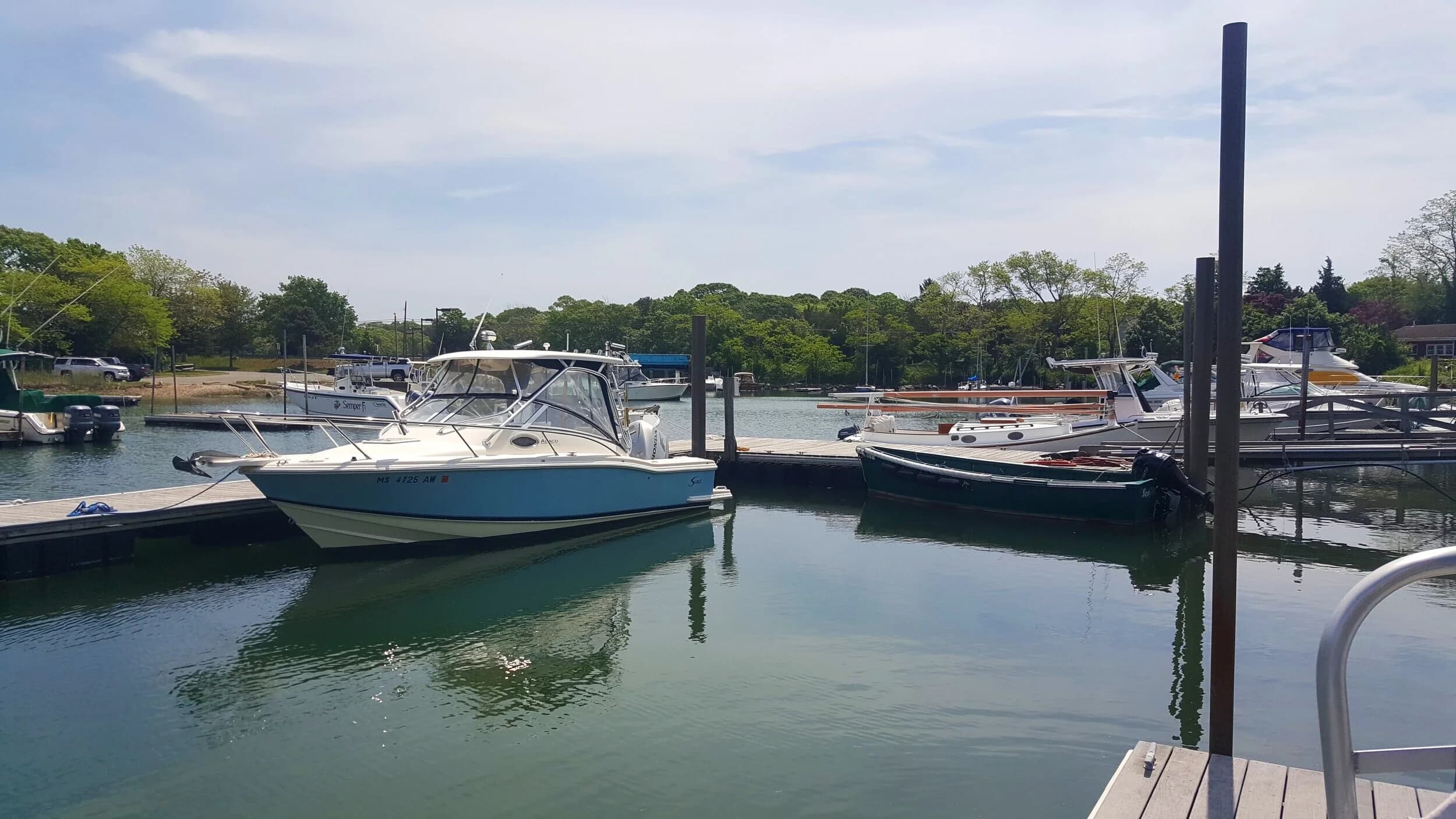 A light-blue powerboat tied up at the floating docks